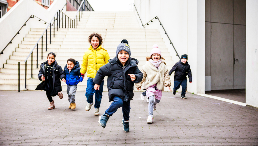Kinderen lopen al spelend in groep